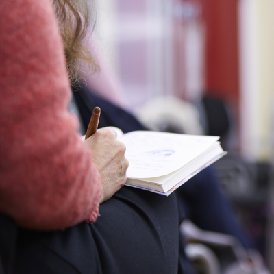 A person's hand writing in a notebook